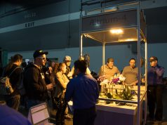 Aessense is Straight Outta Of Mountain View white and purple flowers under light display with crowd surrounding at convention