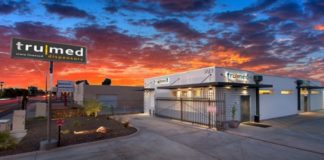 TruMed:Modern, Refined Industrial Chic in the Desert tru med building and parking lot with orange and blue cotton candy sunset