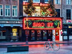 Alaska Takes Step Forward In Opening Marijuana Cafes smokey coffeeshop storefront with bright red lights in amsterdamn