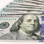 The High Road to Cannabis Payment small fanned out stack of hundred dollar bills focusing on ben franklin