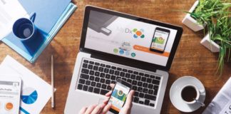 MyDX Brings Cannabis Lab Testing to the Masses woman holding mydx app on phone with a computer and coffee cup on the table