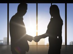 Weedmaps Hires Dustin McDonald For Government Outreach man and woman professionals shaking hands in front of city skyline