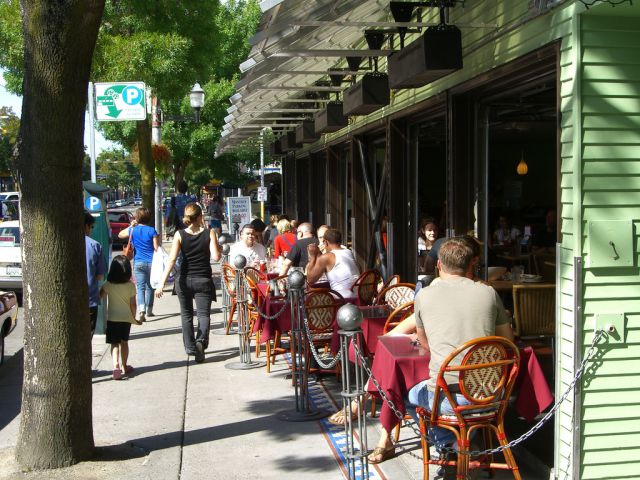 sidewalk cafe with people walking and eating
