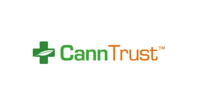 CannTrust Logo white background cann in green trust in black to the left of the text is a green medical cross