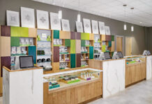 A Closer Look at Visual Merchandising Genius a dispensary counter with light brown and white furniture and splashes of teal and lime green