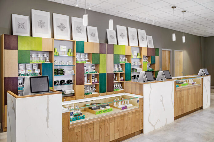 a dispensary counter with light brown and white furniture and splashes of teal and lime green