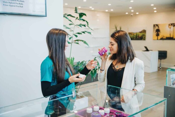 Dispensary budtender letting a customer smell a cannabis flower product