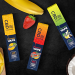 CBD Living Launches New Disposable Vapes with Twice the CBD CBD Living vape packages on a black background amidst fresh fruit