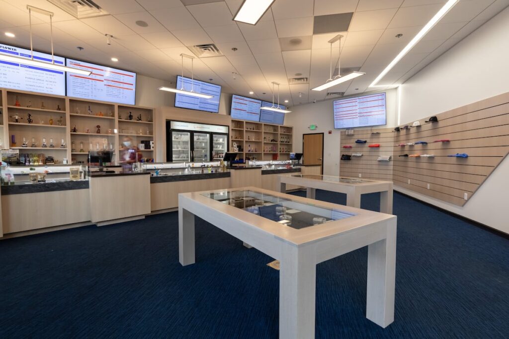 GT Dispensary interior with navy blue carpet and white display cases