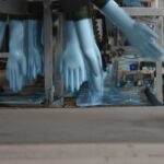 The Truth about Single-Use Gloves blue disposable nitrate gloves running through the production line