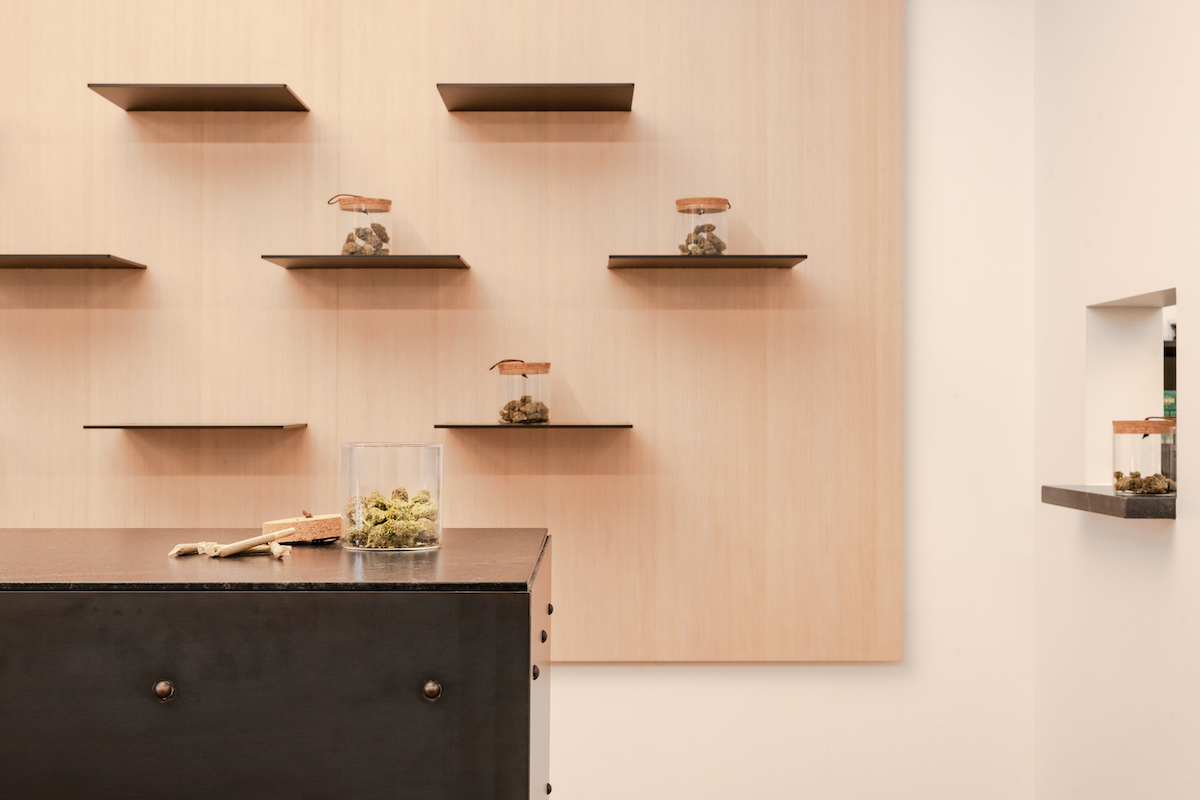 floating shelves with jars of weed on a light wood wall