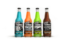 Mary Jones Set to Launch in Washington after Successful California Debut four glass bottles of mary jones soda lined up next to one another one is turqoise and labeled berry lemonade, one is orange and labeled orange and cream, one is lime green and labeled green apple, and one is brown and labeled root beer. The Mary Jones logo sticks out prominently in black and white bold letters on each bottle