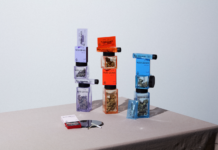 Miss Grass Announces Purposeful Rebrand and Five New SKUs product display of Miss Grass flower a rolled join lays on a table in front of three stacks of weed filled jars, one purple, one red, and one blue