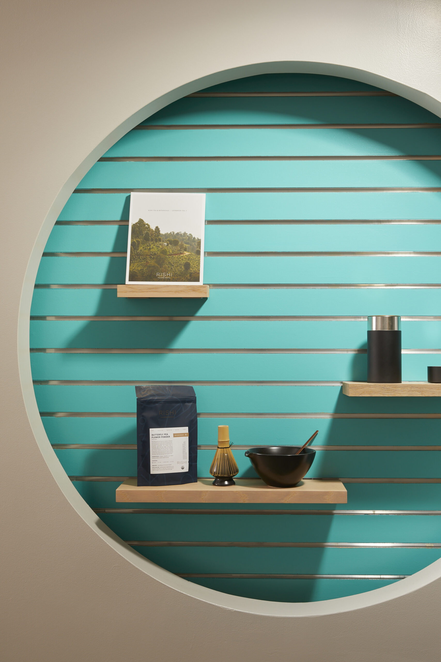 teal display circle on a white wall with floating shelves and little knick knacks 