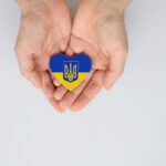 Cannabis Companies Are Stepping up to Help Ukraine two hands holding a Ukraine flag colored heart