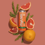 rhythm™ Sparkling Hemp Beverages Announces Re-Brand and Enhanced Product Formulations rhythm seltzer coral background with orange rhythm can in center surrounded by blood orange slices and green sprigs of rosemary