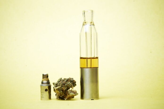 cannabis flower and vape oil with yellow background