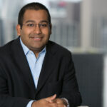 C3 Industries Appoints Valay Shah as Chief Financial Officer professional headshot of a clean shaven man smiling at the camera wearing a black suitcoat and a crisp light blue button up he has black buzzcut hair