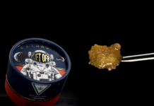 High Life Farms Launches New Line of BHO Extracts in Michigan product image black background lift off extracts container featuring an astronaut on the lid a chunk of golden wax is next to the container