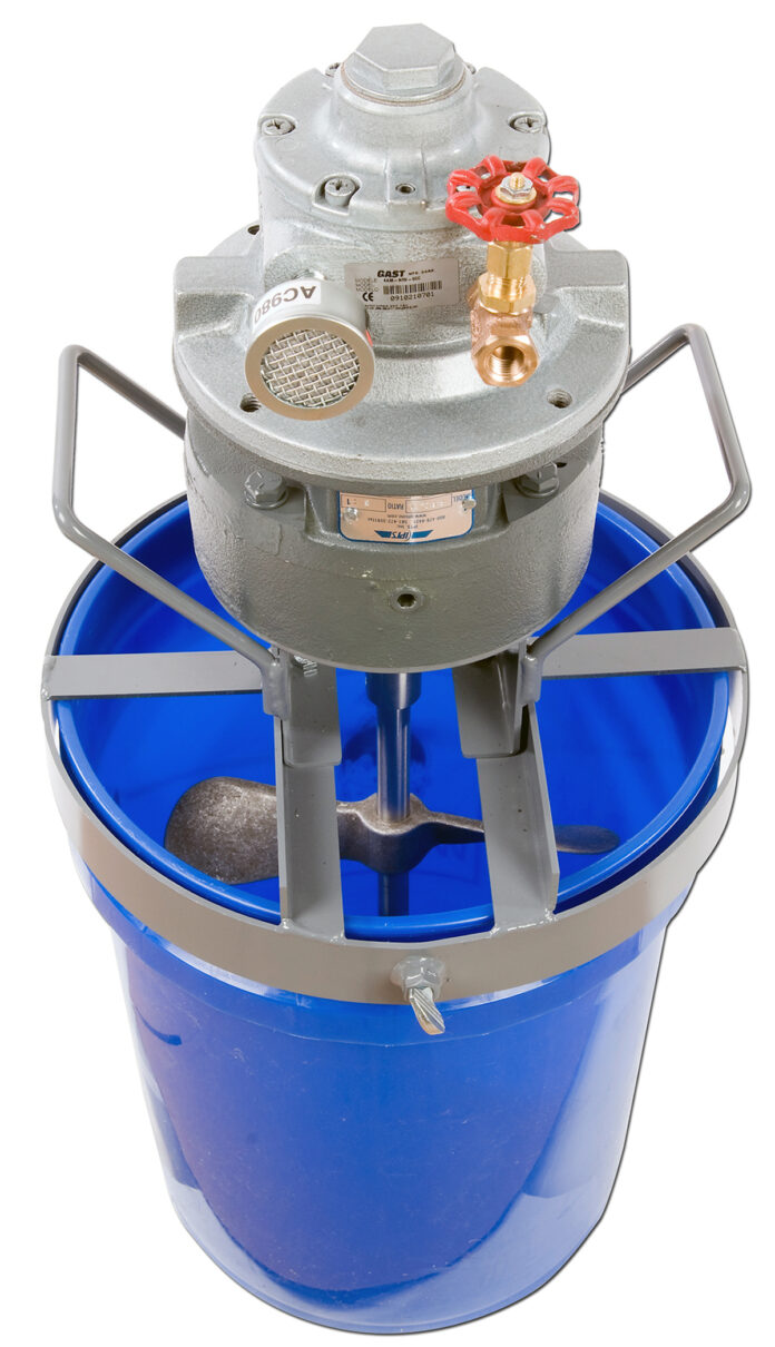 blue five gallon bucket with mechanical contraption on top for processing viscous material