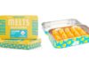 Cheeba chews melts display image the rectangular metal container is opened revealing the orange edibles inside and another container is placed next to the open container showcasing the yellow and blue label