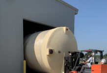 Madison Chemical Invests in Infrastructure to Protect Against Supply Chain Problems photo of an industrial sized barrel being loaded into a pole barn