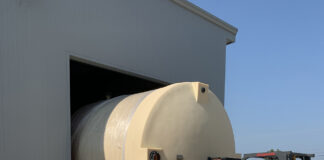 Madison Chemical Invests in Infrastructure to Protect Against Supply Chain Problems photo of an industrial sized barrel being loaded into a pole barn