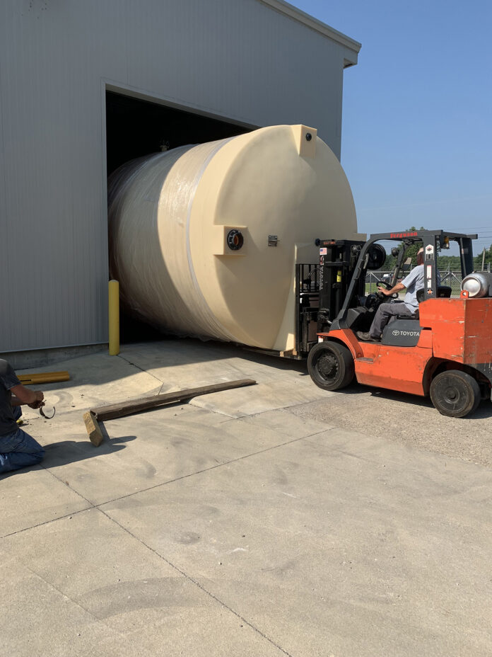 photo of an industrial sized barrel being loaded into a pole barn