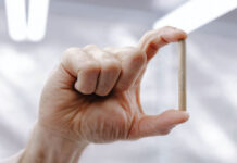 Rolling Out a New Age for Pre-Rolls man's hand holding a pre-roll joint between his index finger and thumb