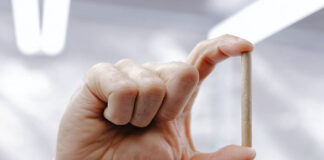 Rolling Out a New Age for Pre-Rolls man's hand holding a pre-roll joint between his index finger and thumb
