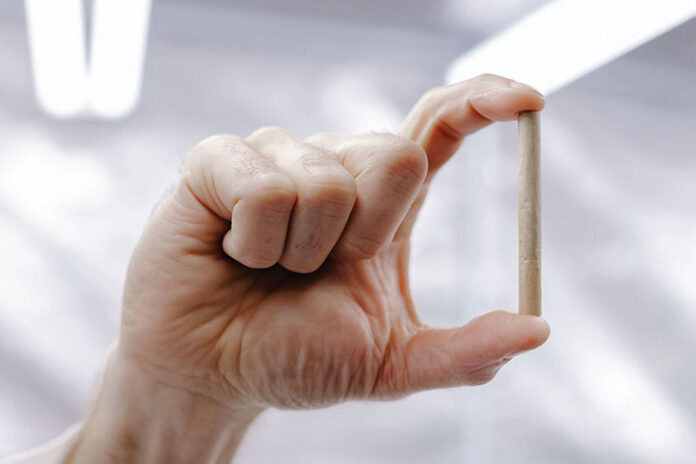 man's hand holding a pre-roll joint between his index finger and thumb