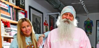 Camp High Launches Brand & Marketing Agency “Camp High Collective” a blonde woman and a man with a big white beard pose for a photo in their leisure sweatsuit line the woman is wearing a light blue sweatsuit and the man is wearing a pink and tie dye sweatsuit