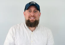 Hydra Unlimited Adds Senior Sales Staff a headshot of a man wearing a white button up a full brown beard and a dark blue baseball hat he is smiling and looking directly at the camera