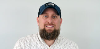 Hydra Unlimited Adds Senior Sales Staff a headshot of a man wearing a white button up a full brown beard and a dark blue baseball hat he is smiling and looking directly at the camera