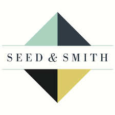 seed and smith logo white background gray capitalized text reading seed and smith with a gray and teal square in the background