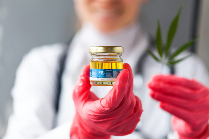 cannabis science with CBD oil and red gloves
