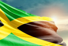 Jamaica: Religion, Culture, and Regulation Jamaica national flag waving in beautiful sky.