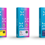 PAX Brings Concentrates Experience to a New Form with Launch of Diamonds Pods for PAX(R) Era™ 💎 product photo white background three pax diamonds packages in blue and pink hombre in the foreground in strawberry cough o g kush and grandaddy purple