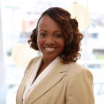 Curaleaf Appoints Tyneeha Rivers As Chief People Officer black professional business woman with wavy hair and a tan shirt