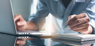 7 Cannabis Schools for Continuing and Professional Education Business planning, E learning concept. Casual business man writing on notebook and working on laptop computer in modern office. Man studying online course via laptop and lecture on notepad.