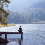 Cannabis as Wellness: Do All Brands Need to Keep Up? Woman practicing yoga at a lake in nature wellness lifestyle