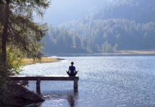 Cannabis as Wellness: Do All Brands Need to Keep Up? Woman practicing yoga at a lake in nature wellness lifestyle