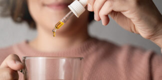 Group Proposes New Framework for Evaluating Hemp Product Safety Cbd hemp oil - Woman taking cannabis oil in tea cup - Focus on drop