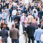 5 Essential Tips for Your Big Return to In-Person Conferences Crowd of anonymous business people at an industry conference expo event