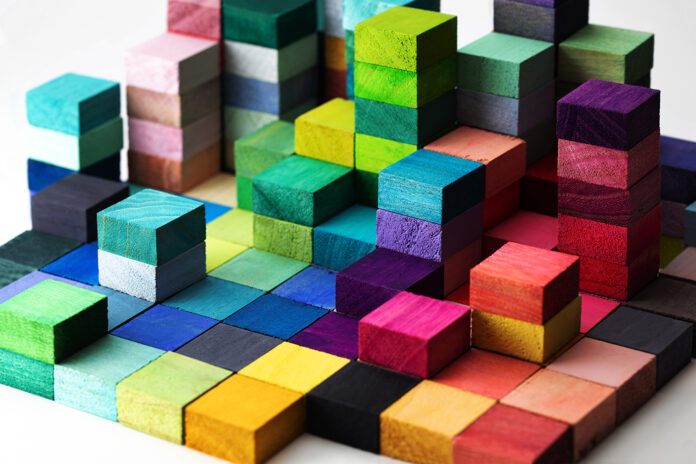 Spectrum of stacked multi-colored wooden blocks. Background or cover for something creative, diverse, expanding, rising or growing.