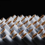 The Cannabis-Tobacco Worm Turns Cigarettes. Tobacco product. Heap of Tobacco Cigarettes on black background, close up from the front. Panoramic macro image, hi-res banner.