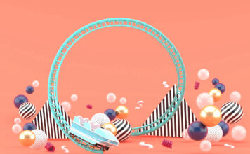 A Blue Roller Coaster Among Colorful Balls On A Pink background