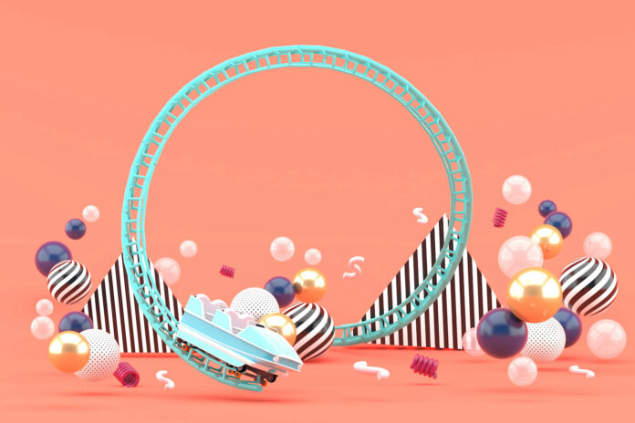 A Blue Roller Coaster Among Colorful Balls On A Pink background