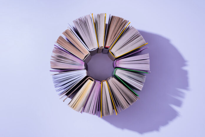 Top,View,Of,Stack,Of,Books,In,Circle,On,Violet
