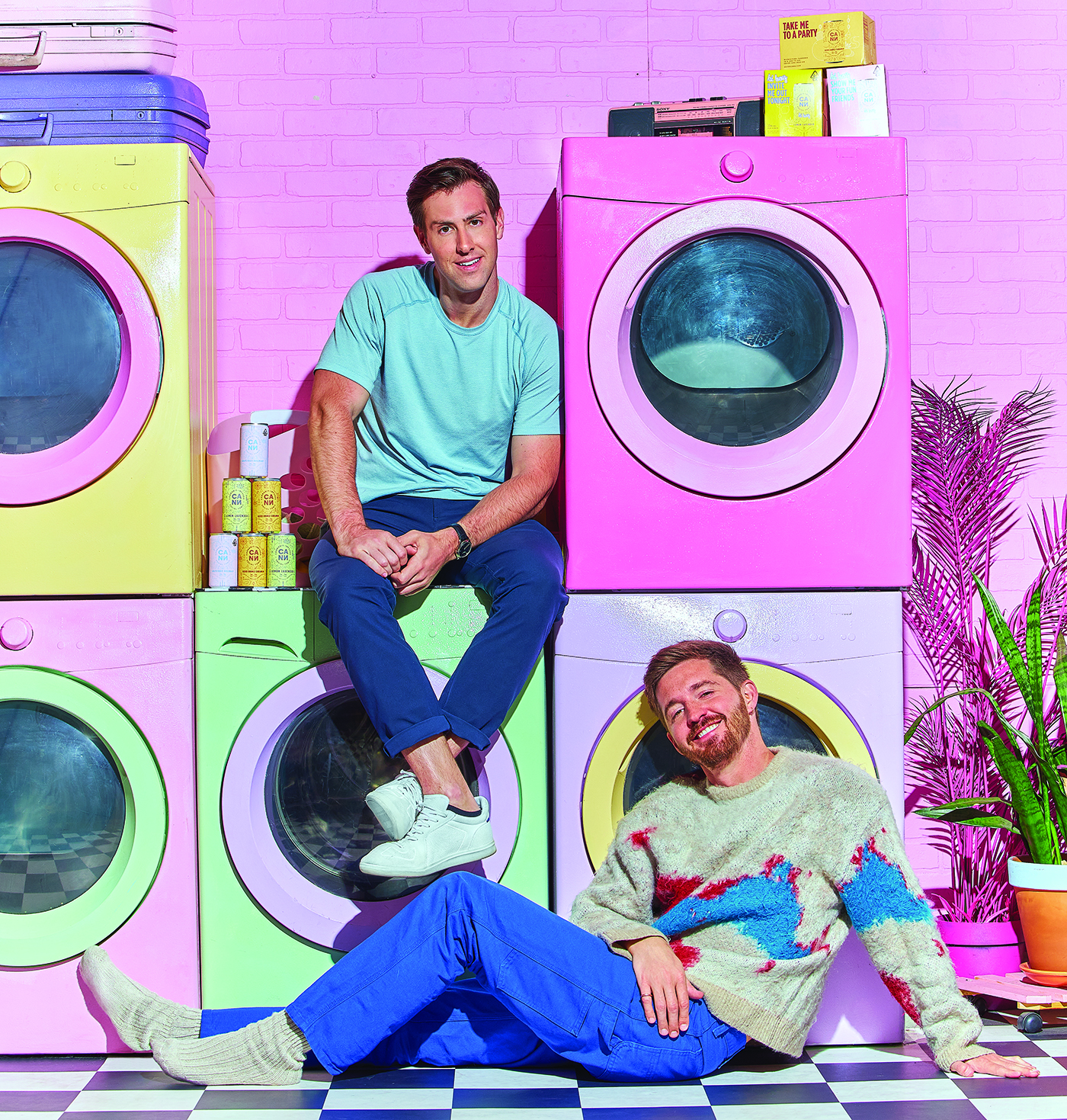 two men in a brightly colored laundry room with pastel colored washers